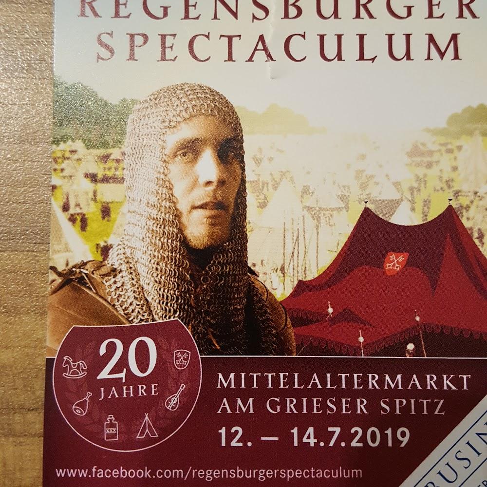 A man in a chainmail hood stands in front of a tent. The text says 